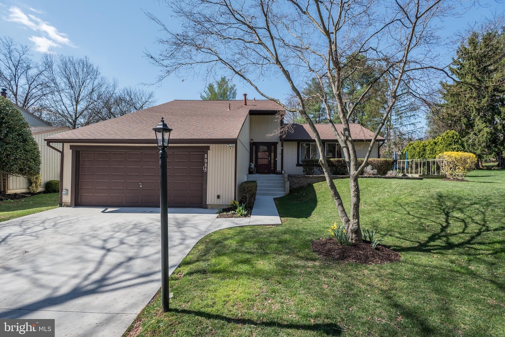 view of front of property with a garage, roof with shingles, concrete driveway, and a front lawn