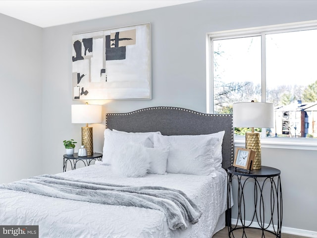 bedroom with baseboards and wood finished floors