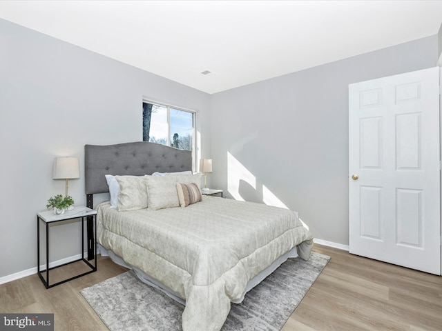 bedroom with light wood-style floors and baseboards