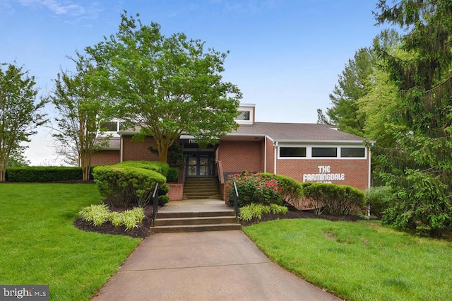 view of front of house with a front lawn and brick siding