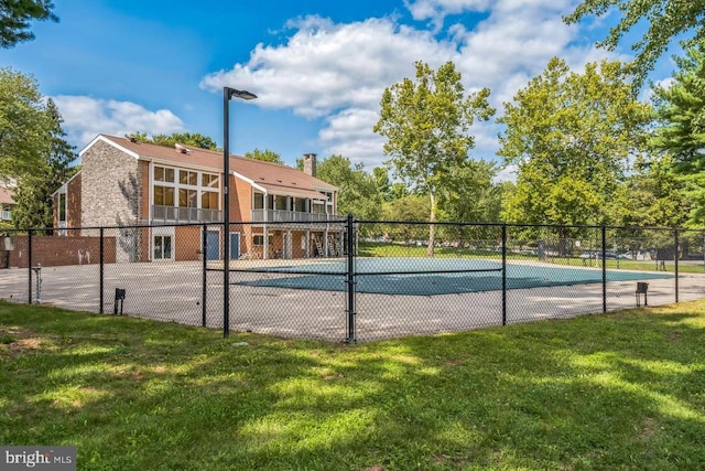 view of sport court featuring a yard, fence, and a community pool