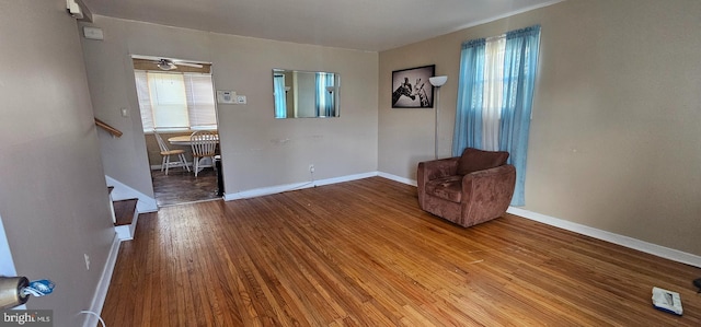 living area with a healthy amount of sunlight, baseboards, and wood finished floors