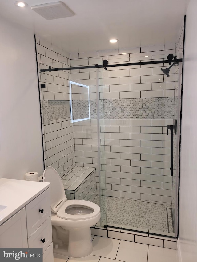 bathroom with tile patterned flooring, a shower stall, toilet, and vanity