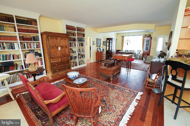 sitting room with wood finished floors and a notable chandelier