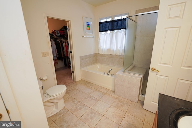 full bath featuring a walk in closet, toilet, a shower stall, a bath, and tile patterned floors