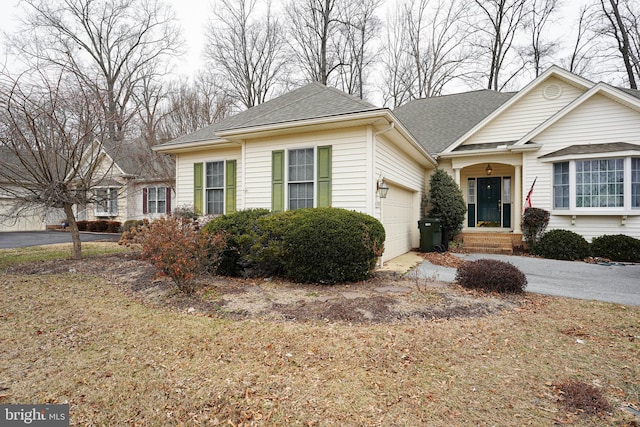 view of front of property with roof with shingles, driveway, and an attached garage