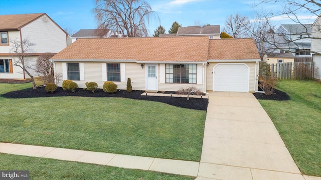 ranch-style home with driveway, an attached garage, fence, and a front yard