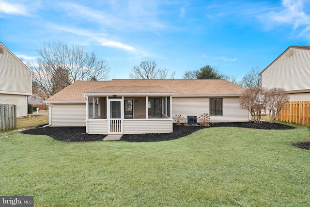 back of house featuring central air condition unit, fence, a sunroom, roof with shingles, and a lawn