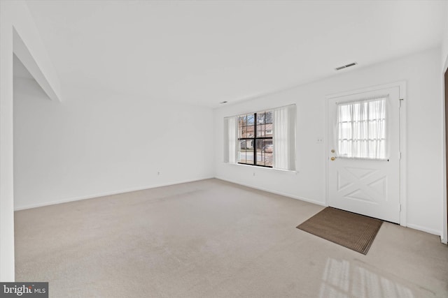 entryway with light carpet, visible vents, and baseboards