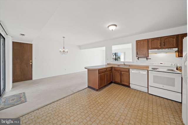 kitchen featuring light countertops, hanging light fixtures, a peninsula, white appliances, and under cabinet range hood