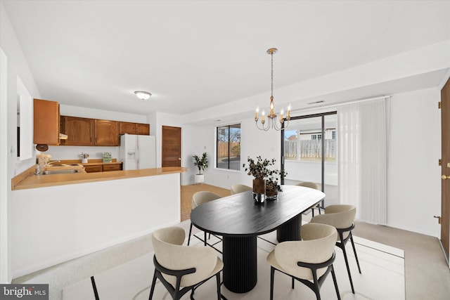 dining area with a chandelier and light carpet