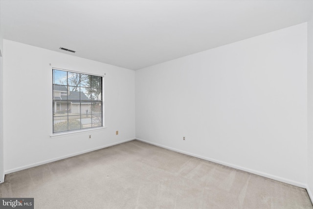 spare room with light carpet, baseboards, and visible vents