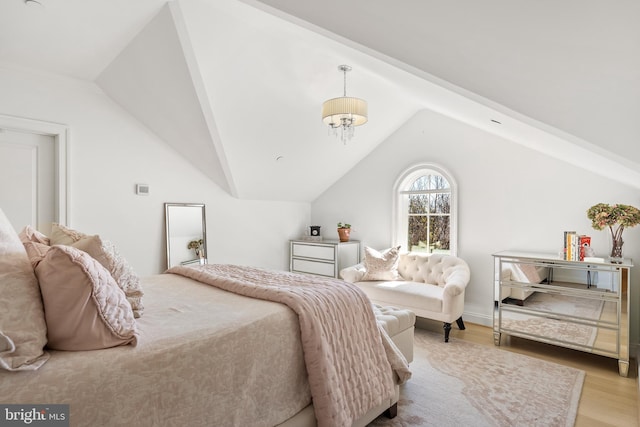 bedroom with vaulted ceiling, wood finished floors, and a chandelier