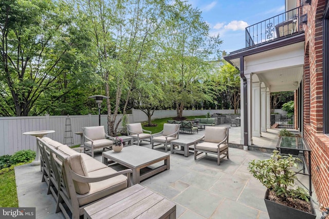 view of patio / terrace featuring outdoor lounge area, fence, and a balcony