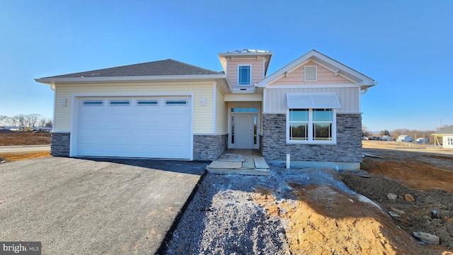 view of front facade with aphalt driveway, stone siding, board and batten siding, and an attached garage