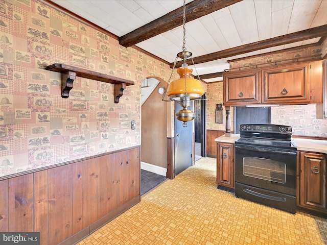 kitchen with pendant lighting, a wainscoted wall, beam ceiling, light countertops, and black range with electric cooktop