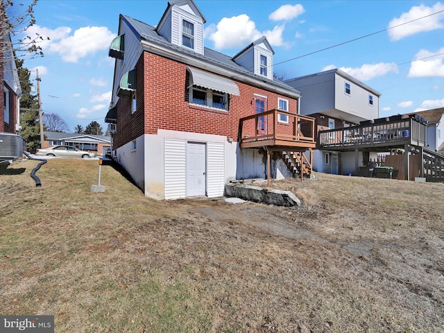 back of property with a wooden deck, central AC unit, stairway, a yard, and brick siding