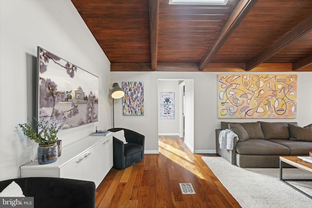 living area with beam ceiling, visible vents, wood finished floors, wooden ceiling, and baseboards