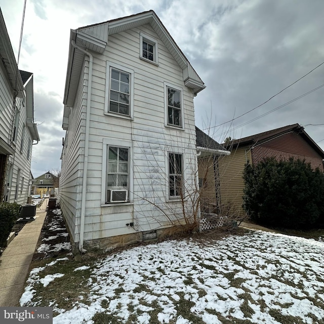 snow covered property with cooling unit