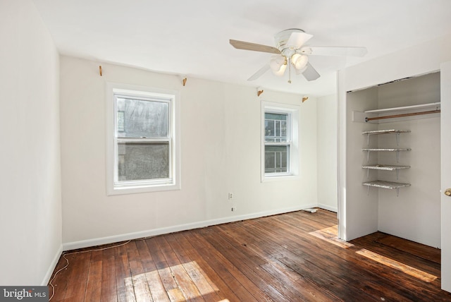 unfurnished bedroom featuring dark wood-style floors, a ceiling fan, baseboards, and a closet