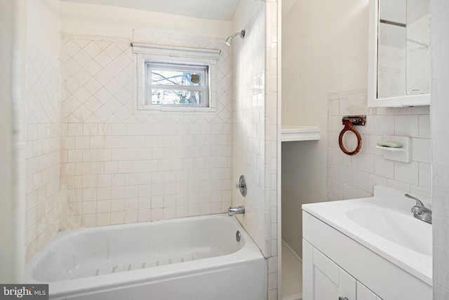 full bath featuring tile walls, vanity, and bathing tub / shower combination