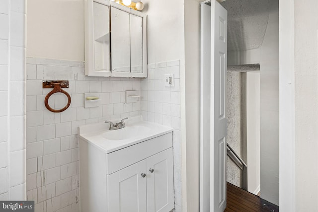 bathroom with tile walls, wainscoting, and vanity