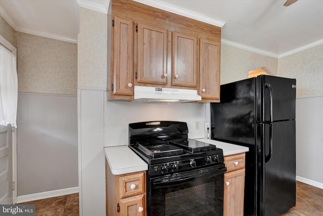 kitchen featuring black appliances, under cabinet range hood, light countertops, and a wainscoted wall