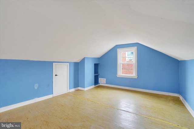 bonus room with lofted ceiling, concrete flooring, visible vents, and baseboards