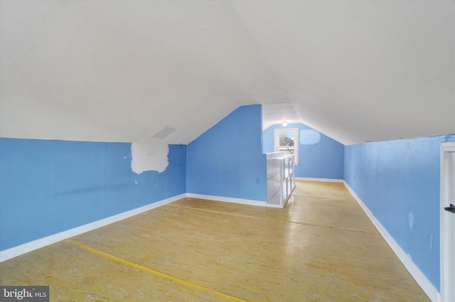 additional living space with lofted ceiling, wood finished floors, and baseboards