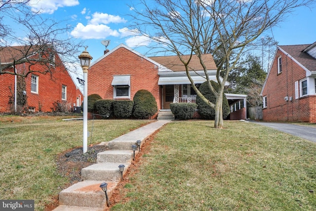 bungalow-style house featuring brick siding, a front yard, and aphalt driveway