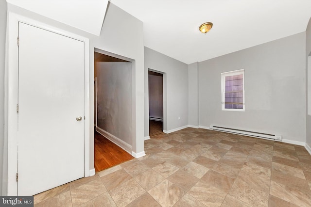 unfurnished room featuring baseboard heating, a baseboard radiator, and baseboards