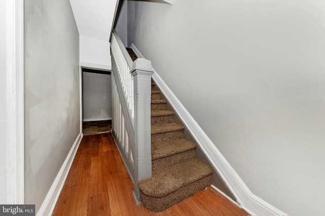 stairs with wood finished floors and baseboards