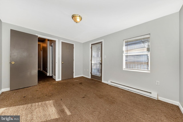 unfurnished bedroom with a baseboard heating unit, dark carpet, and baseboards