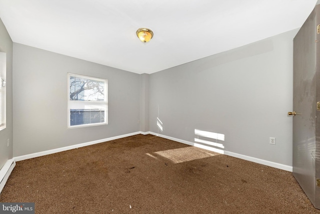 carpeted spare room featuring baseboards