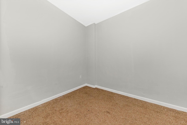 unfurnished room with vaulted ceiling, carpet floors, and baseboards