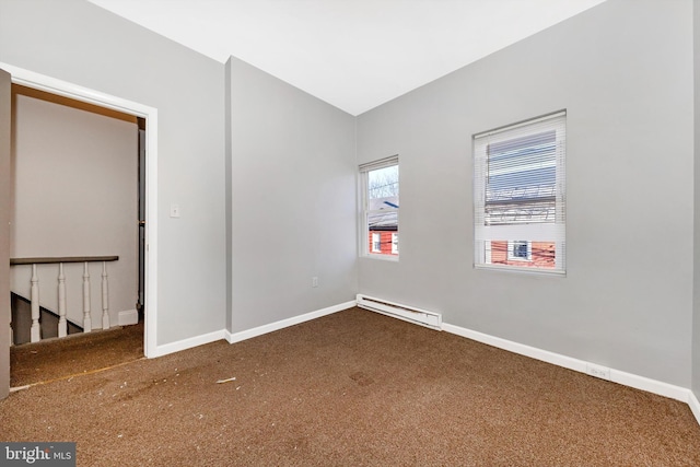 empty room featuring a baseboard heating unit and baseboards