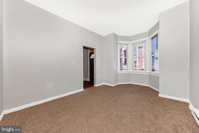 unfurnished room with carpet and baseboards