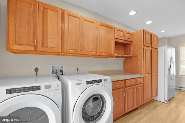 laundry room with light wood-type flooring, cabinet space, washing machine and dryer, and recessed lighting