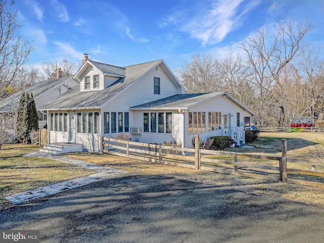 view of front of home featuring roof with shingles, a fenced front yard, and a chimney