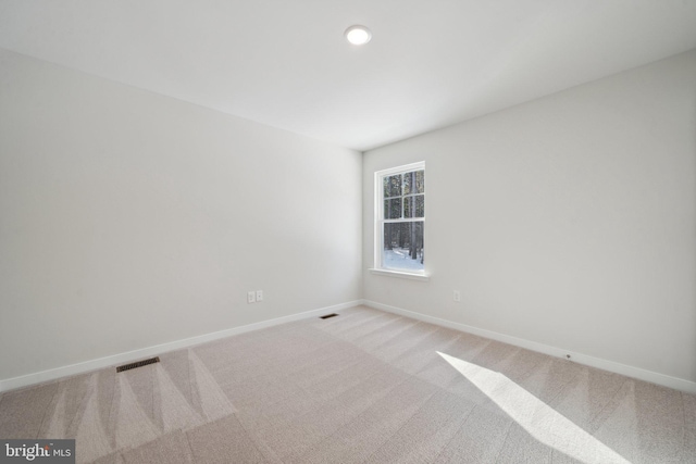 carpeted empty room featuring baseboards, visible vents, and recessed lighting