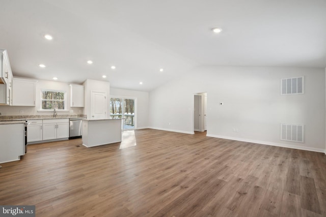 kitchen with visible vents, white cabinets, dishwasher, open floor plan, and light countertops