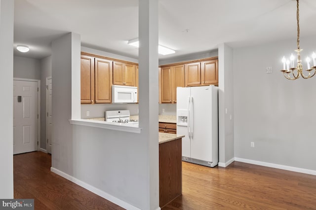 kitchen featuring white appliances, baseboards, wood finished floors, and decorative light fixtures