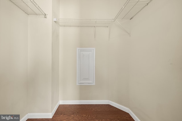 walk in closet with wood finished floors