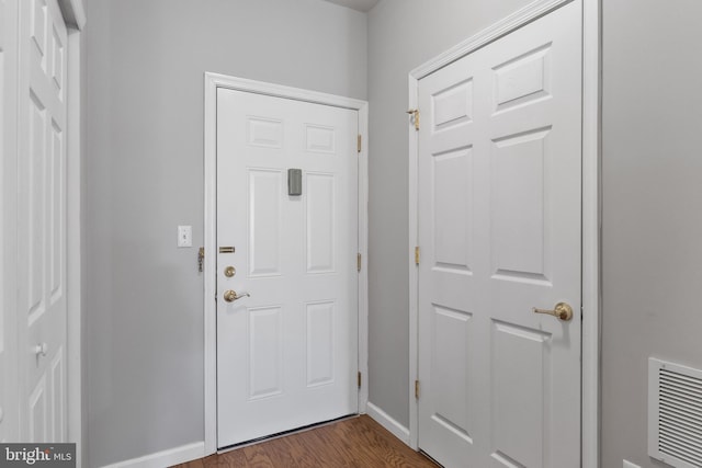 foyer featuring visible vents, dark wood finished floors, and baseboards