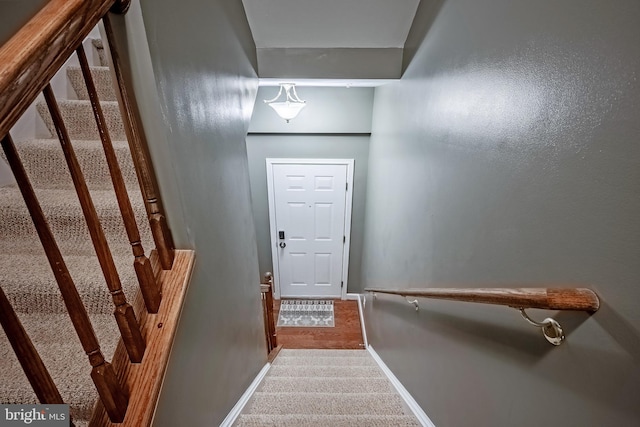 stairs featuring carpet flooring and baseboards