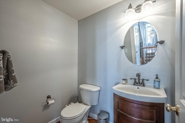 bathroom featuring toilet, baseboards, and vanity