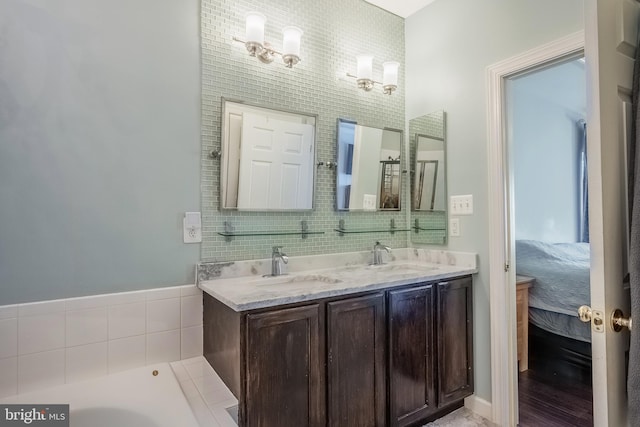 ensuite bathroom featuring double vanity, a sink, tile walls, and ensuite bathroom