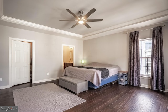 bedroom featuring a tray ceiling, dark wood finished floors, and baseboards