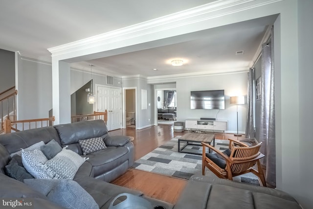 living area with ornamental molding, wood finished floors, and visible vents