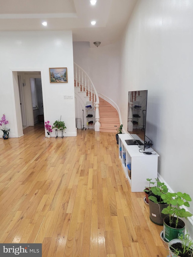 living area featuring light wood-type flooring, recessed lighting, and stairs